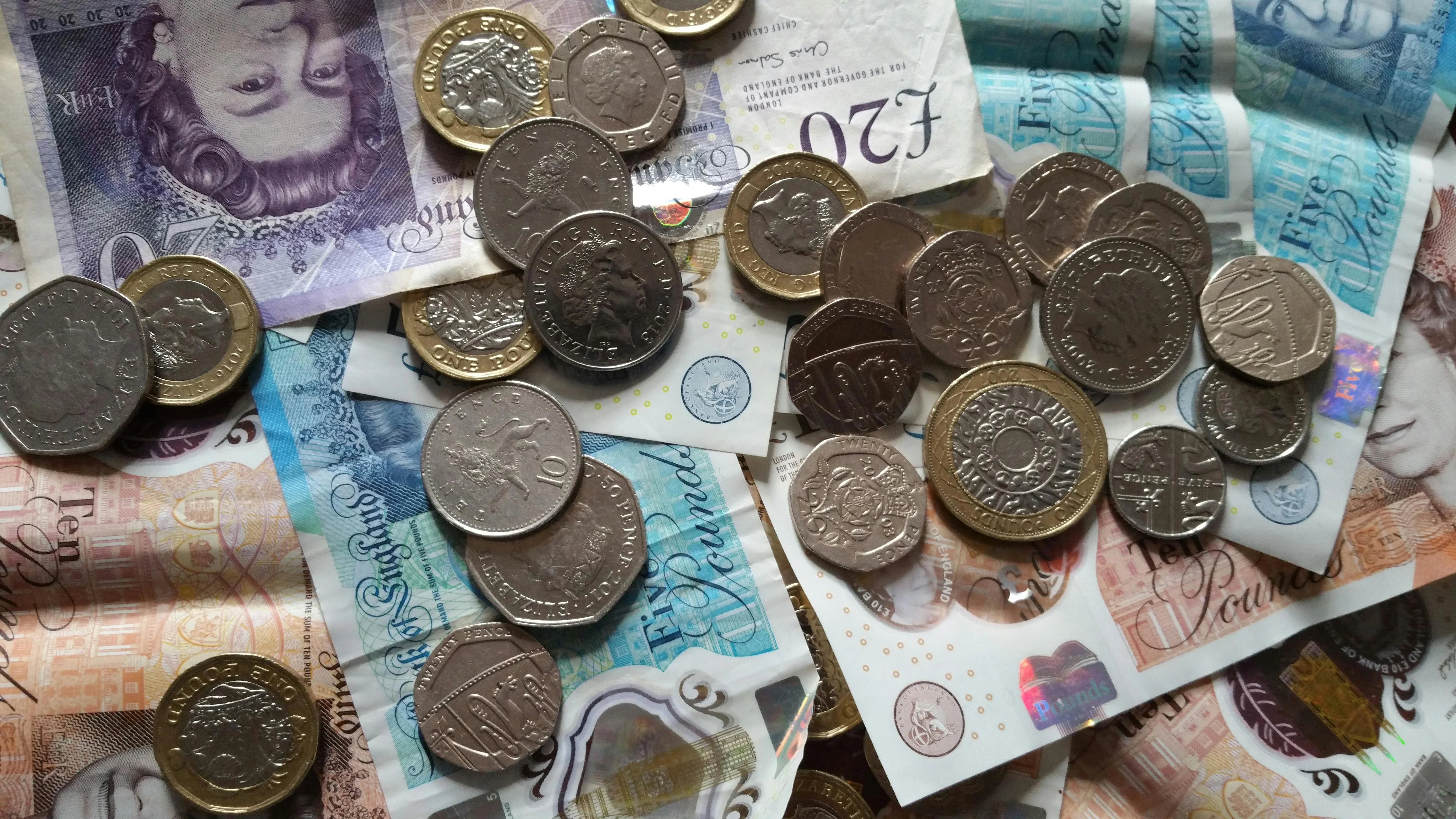 stack of British pound notes and coins